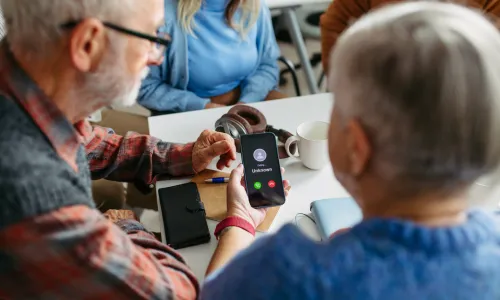 Older adult looking at an incoming call on a phone